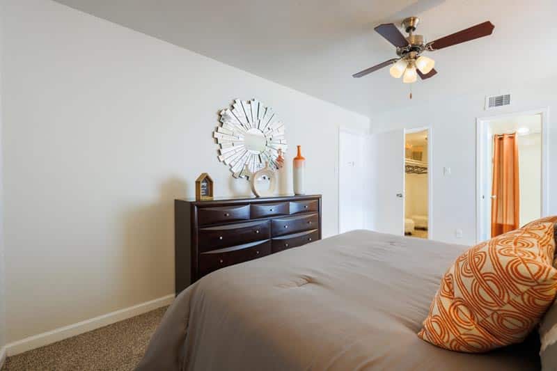 Spacious master bedroom with ceiling fan and bright natural light at The Brook on Bay Area in Webster TX
