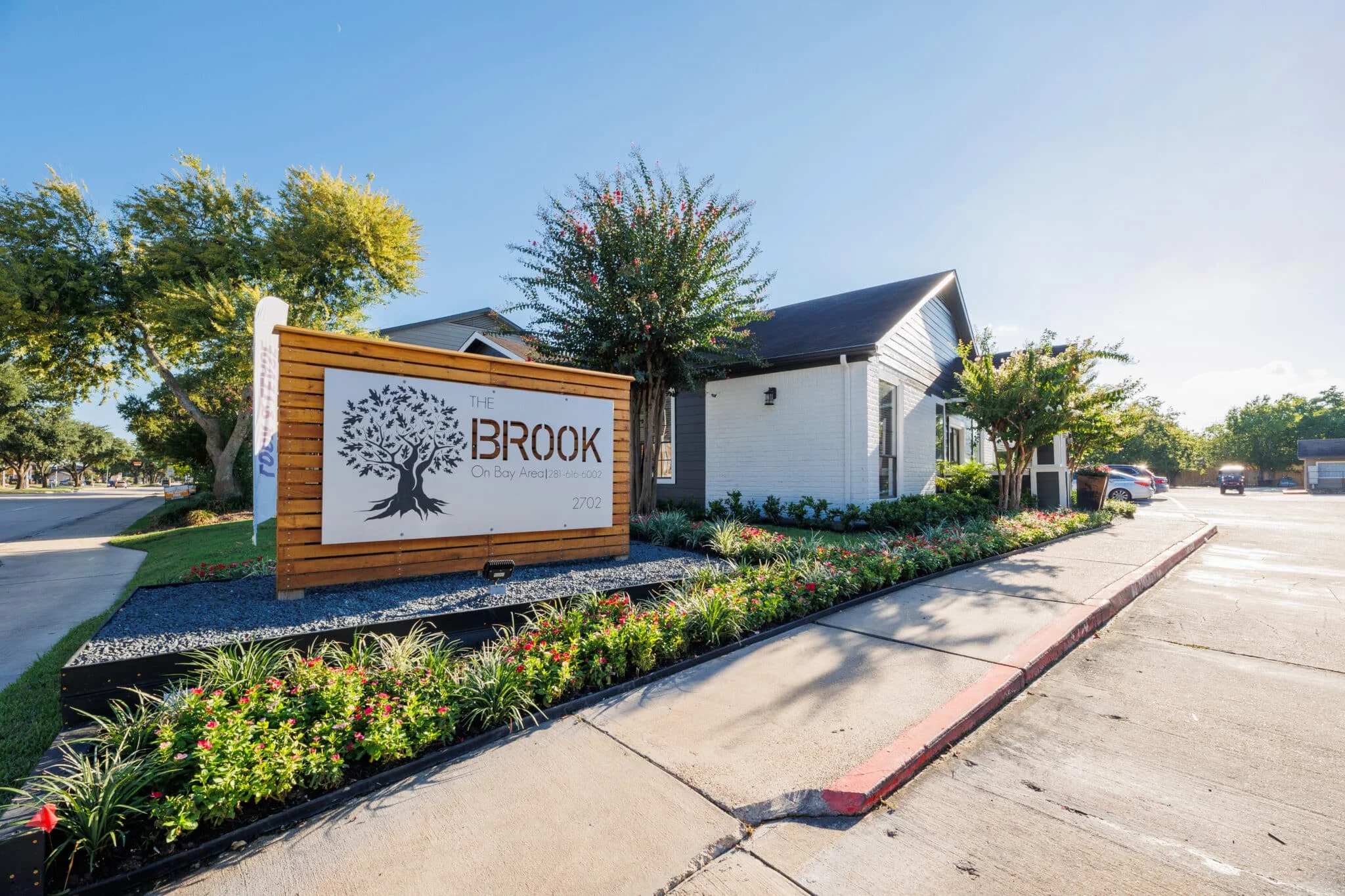 Entrance signage and landscaped exterior of The Brook on Bay Area apartments, highlighting modern community living in a well-maintained residential neighborhood